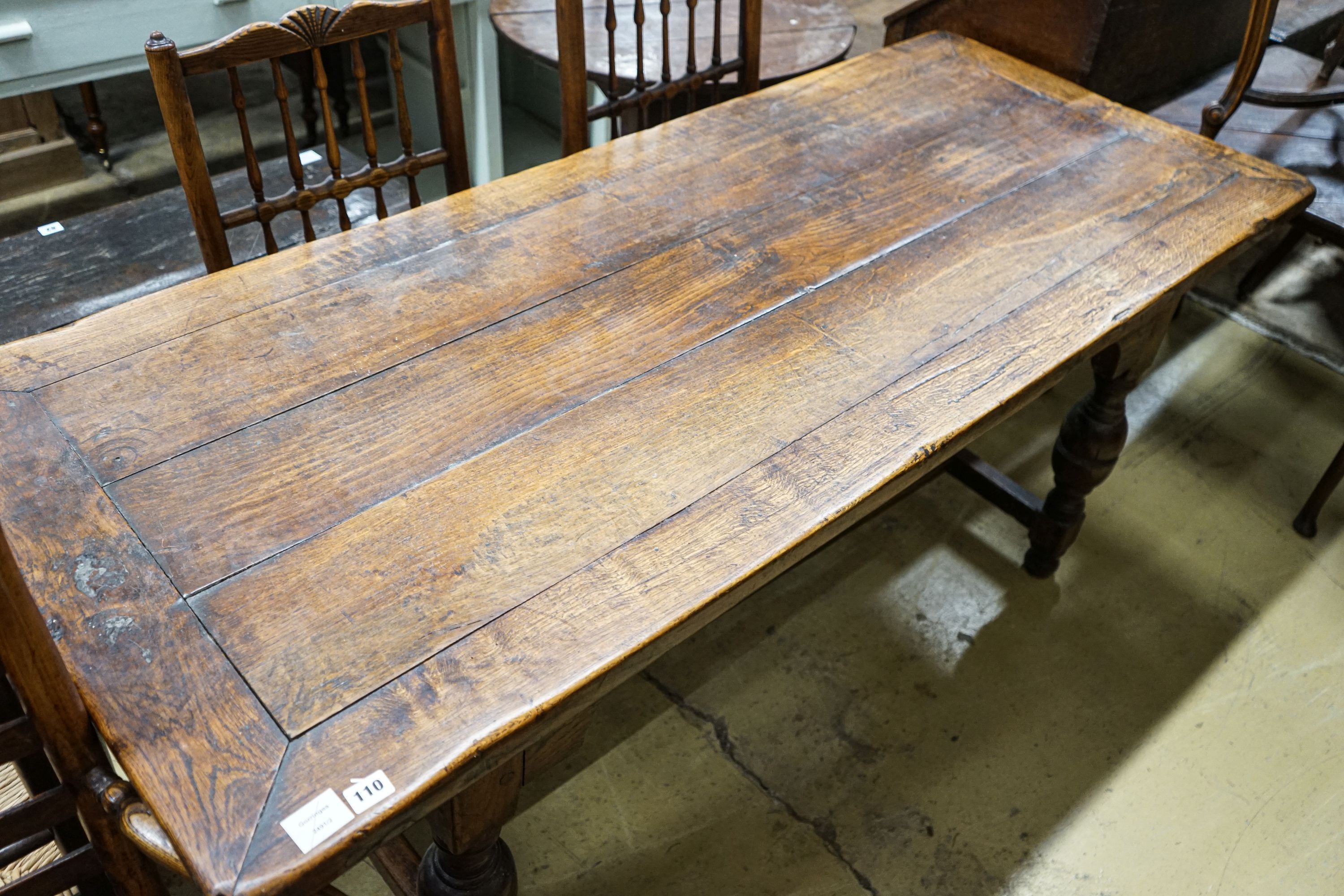 A 17th century style oak refectory table, with cup and cover legs and H stretcher, length 177, depth 74cm, height 77cm
